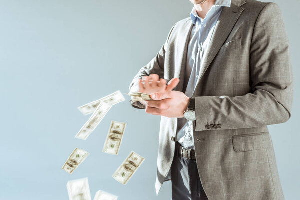 Close-up view businessman throwing money isolated on grey