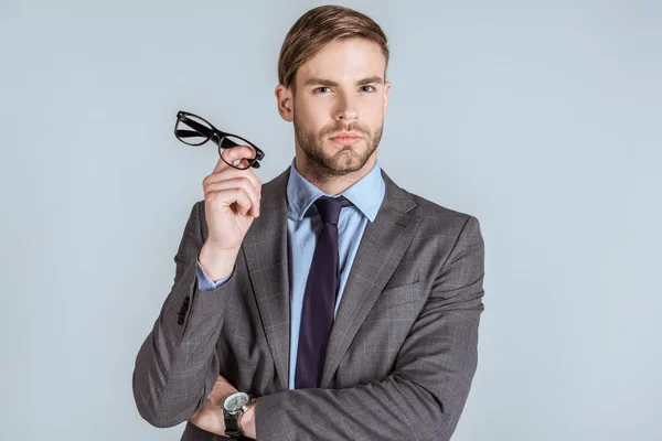Jovem Empresário Confiante Segurando Óculos Isolados Cinza — Fotografia de Stock