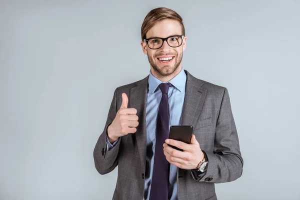 Young Smiling Businessman Using Smartphone Showing Thumb Isolated Grey — Stock Photo, Image