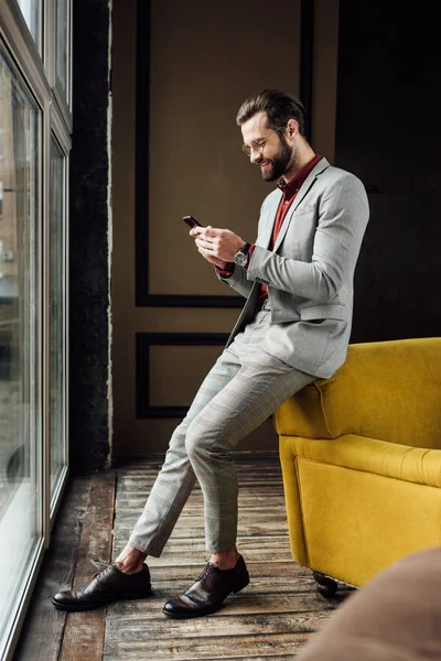 Hombre Guapo Con Estilo Usando Teléfono Inteligente Sentado Ventana — Foto de Stock