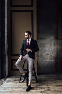 yakışıklı moda iş adamı dışkı çatı iç poz takım elbise 