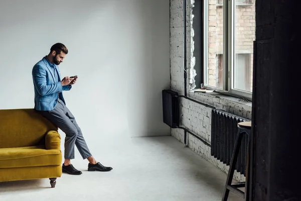 Homem Elegante Terno Azul Usando Smartphone Sofá Amarelo — Fotografia de Stock