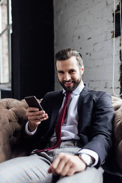 Knappe Lachende Zakenman Met Behulp Van Smartphone Zitten Een Leunstoel — Stockfoto