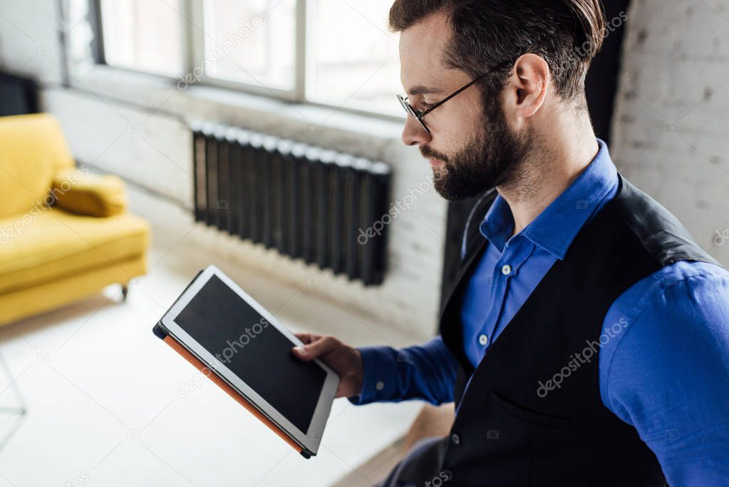stylish bearded man using digital tablet with blank screen