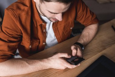 genç adamın hesap makinesini kullanarak yüksek açılı görünüş