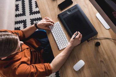 İşyerinde tablet çizim ile genç tasarımcı çalışma yüksek açılı görünüş