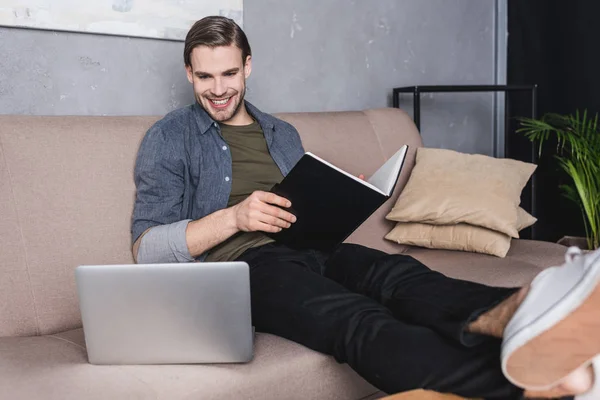 Jovem Homem Negócios Feliz Lendo Notas Sofá Olhando Para Laptop — Fotos gratuitas