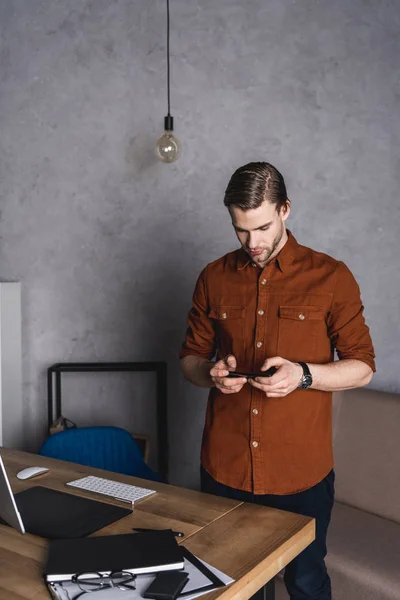 Jovem Empresário Bonito Usando Smartphone Enquanto Está Perto Local Trabalho — Fotografia de Stock