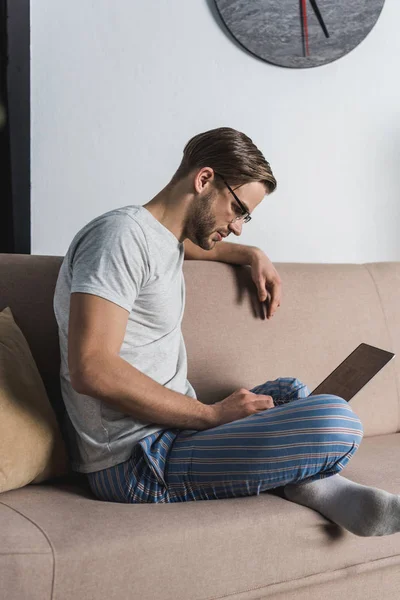 Lachende Freelancer Pyjama Met Behulp Van Laptop Bank — Gratis stockfoto