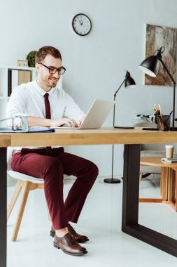 yakışıklı işadamı belgeleri ile modern ofis içinde laptop ile çalışma