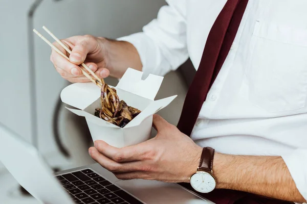 Vista Ritagliata Uomo Affari Con Computer Portatile Mangiare Tagliatelle Ufficio — Foto Stock