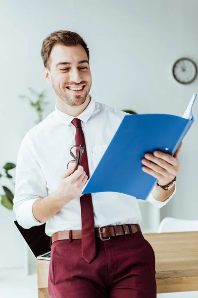 Guapo Sonriente Hombre Negocios Mirando Carpeta Con Documentos — Foto de stock gratuita