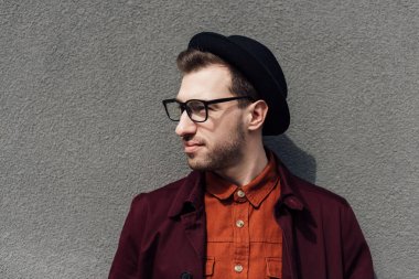 gri duvara ayakta gözlük yakışıklı adam portresi