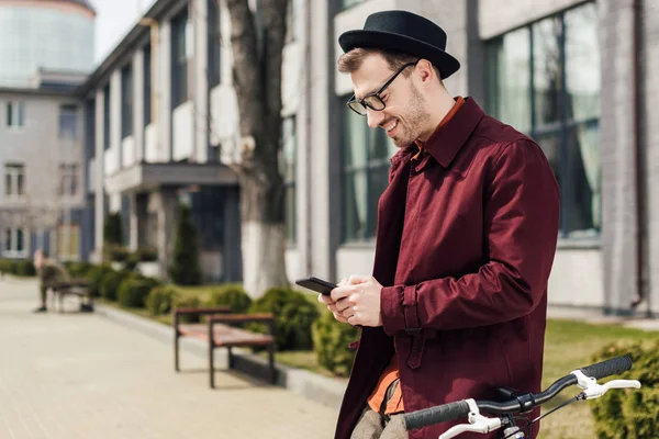 Ευτυχισμένος Όμορφος Άνδρας Γυαλιά Χρησιμοποιώντας Smartphone Κλίνοντας Ποδηλάτου — Φωτογραφία Αρχείου