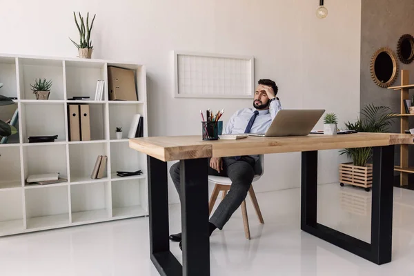 Бизнесмен сидит за столом с ноутбуком — стоковое фото