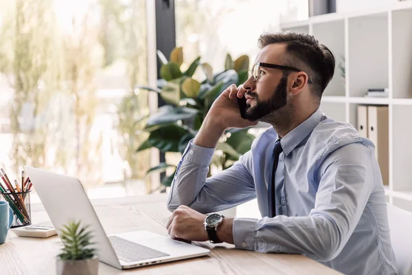 Homme d'affaires utilisant ordinateur portable et smartphone — Photo de stock