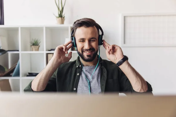 Homem sorridente em fones de ouvido — Fotografia de Stock