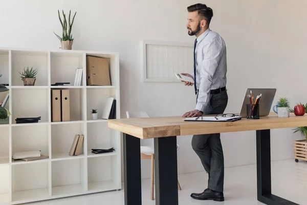 Geschäftsmann steht am Tisch — Stockfoto