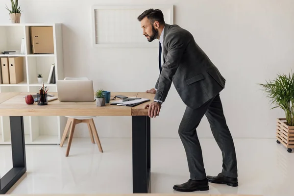 Empresario de pie en la mesa - foto de stock