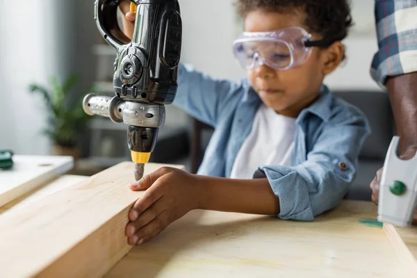 African boy playing with toy drill — Stock Photo