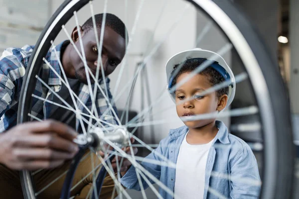 Afro pai e filho reparação de bicicleta — Fotografia de Stock