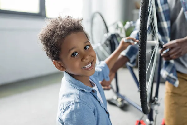 Adorabile afro ragazzo riparazione bicicletta — Foto stock