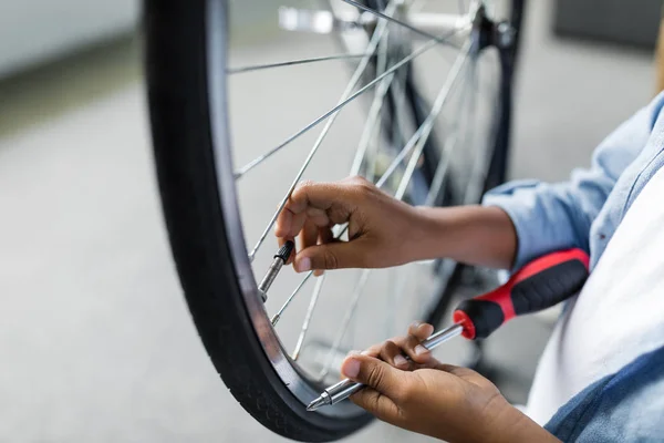 Kleiner Afro-Junge repariert Fahrrad — Stockfoto