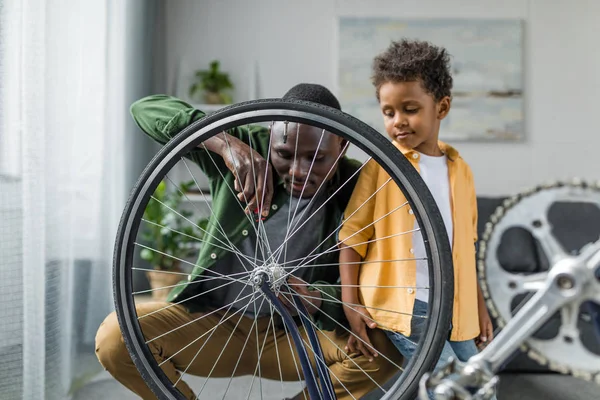 Afro père et fils réparation vélo — Photo de stock