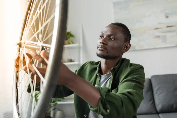 Afro uomo riparazione bicicletta a casa — Foto stock