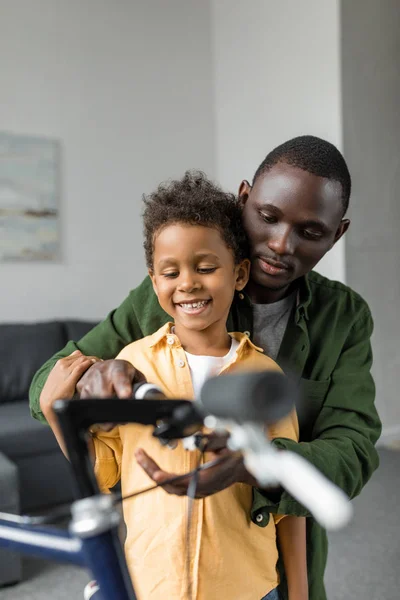 Happy father and son playing with bicycle — Stock Photo