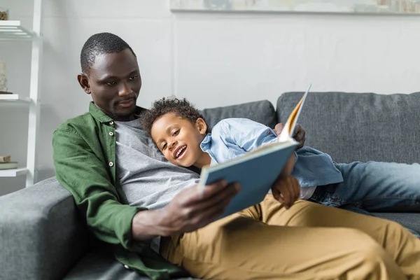 Padre e hijo leyendo el libro juntos - foto de stock