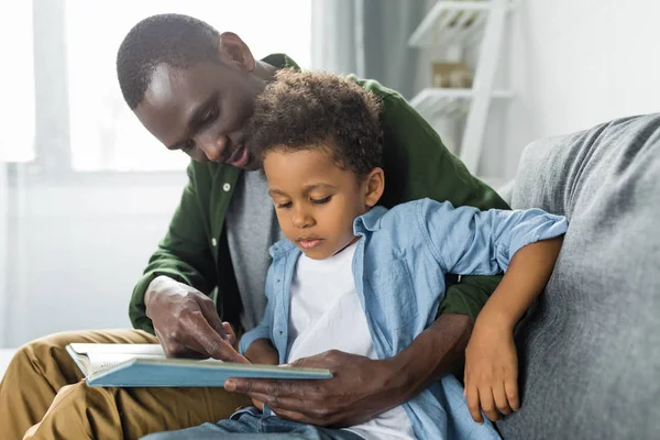 Père et fils lisant ensemble le livre — Photo de stock