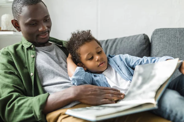 Pai e filho lendo livro juntos — Fotografia de Stock