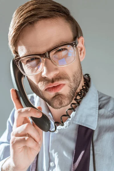Nahaufnahme eines unzufriedenen Geschäftsmannes, der isoliert auf grau telefoniert — Stockfoto