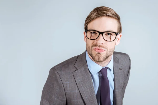 Junger konzentrierter Geschäftsmann blickt isoliert auf graue Kamera — Stockfoto