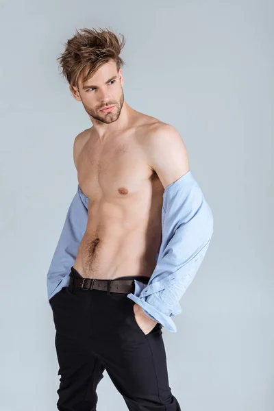 Handsome businessman with messy hair taking off his shirt, isolated on grey — Stock Photo