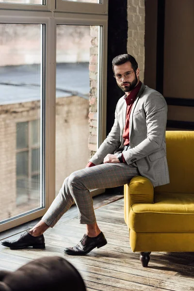 Homem elegante na moda em terno moderno posando na janela — Fotografia de Stock