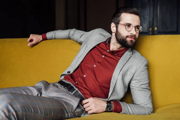 Бородатий елегантний чоловік розслабляється на дивані — стокове фото