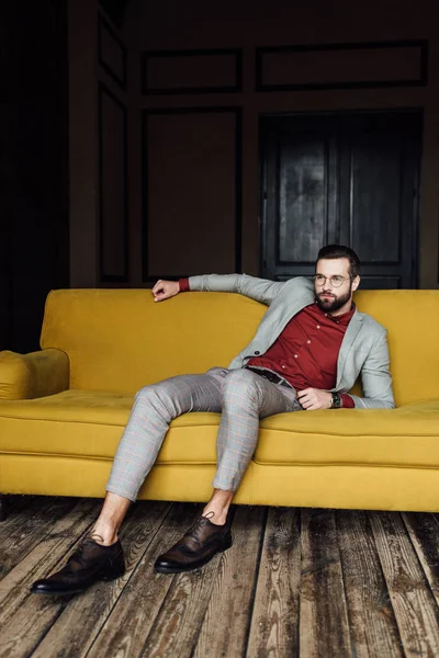 Bel homme élégant reposant sur le canapé — Photo de stock