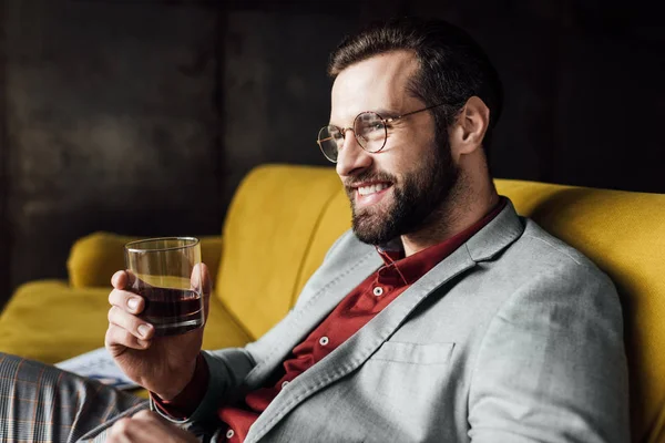 Homem alegre elegante segurando vidro de uísque — Fotografia de Stock