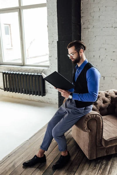 Uomo d'affari elegante alla moda che legge notebook in loft interno — Foto stock