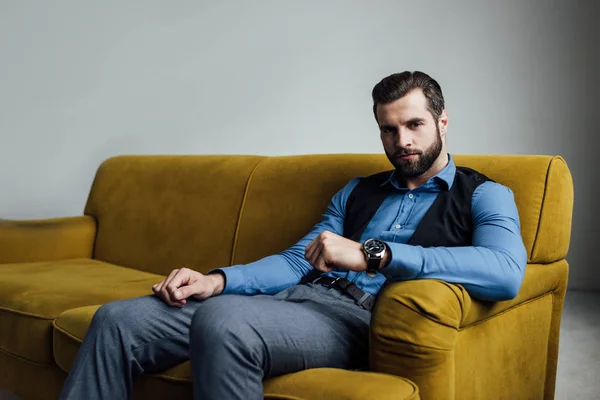 Стильний елегантний чоловік сидить на жовтому дивані — стокове фото