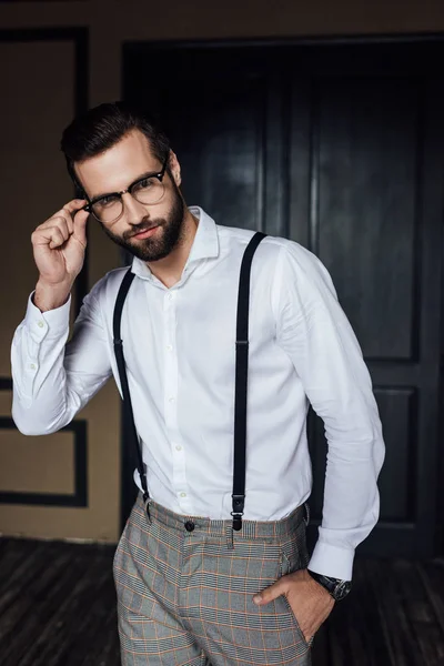 Fashionable man posing in glasses, white shirt and suspenders — Stock Photo