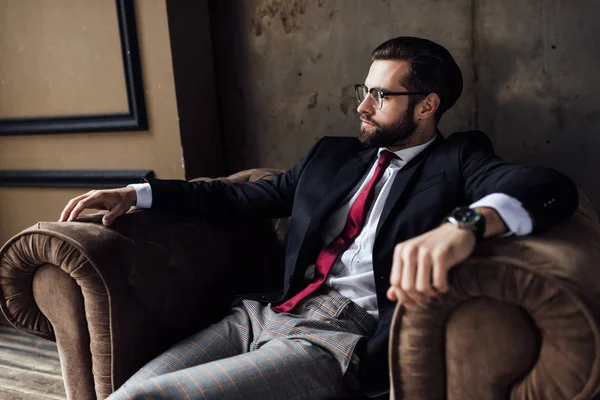Впевнений бородатий бізнесмен сидить у кріслі — стокове фото