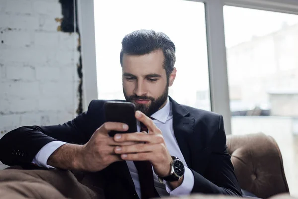 Bello uomo d'affari barbuto utilizzando smartphone — Foto stock