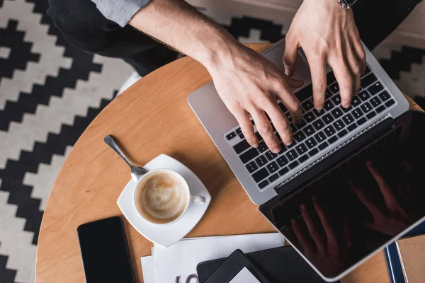 Recortado tiro fo hombre usando portátil en mesa de café — Stock Photo