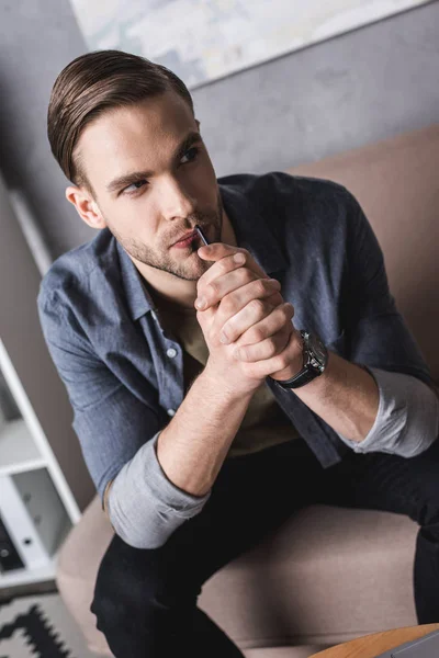 Réfléchi jeune homme avec smartphone dans les mains en attente d'appel — Stock Photo