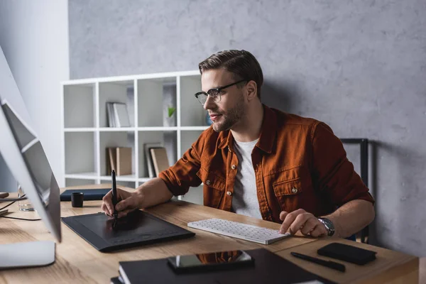 Fiducioso giovane designer che lavora con tablet disegno in ufficio moderno — Foto stock