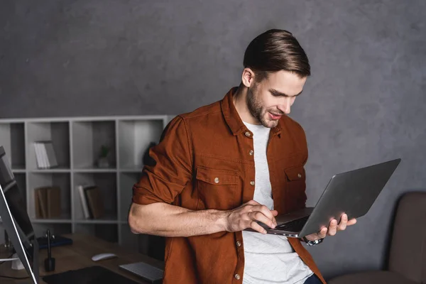 Junger schöner Mann arbeitet mit Laptop — Stockfoto