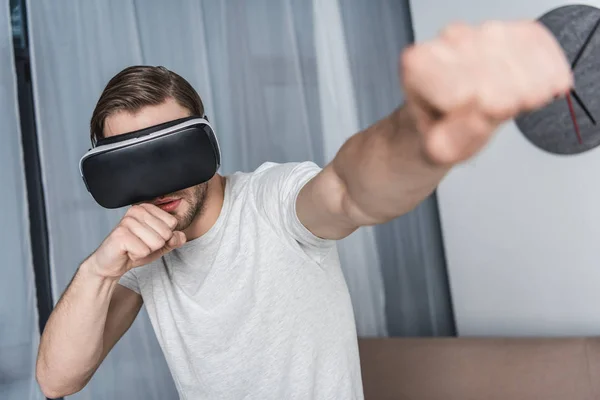 Handsome young man in virtual reality headset playing fighting game — Stock Photo